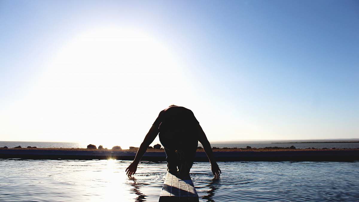 la paz person kneeling on wood surface surrounded by body of water mexico
